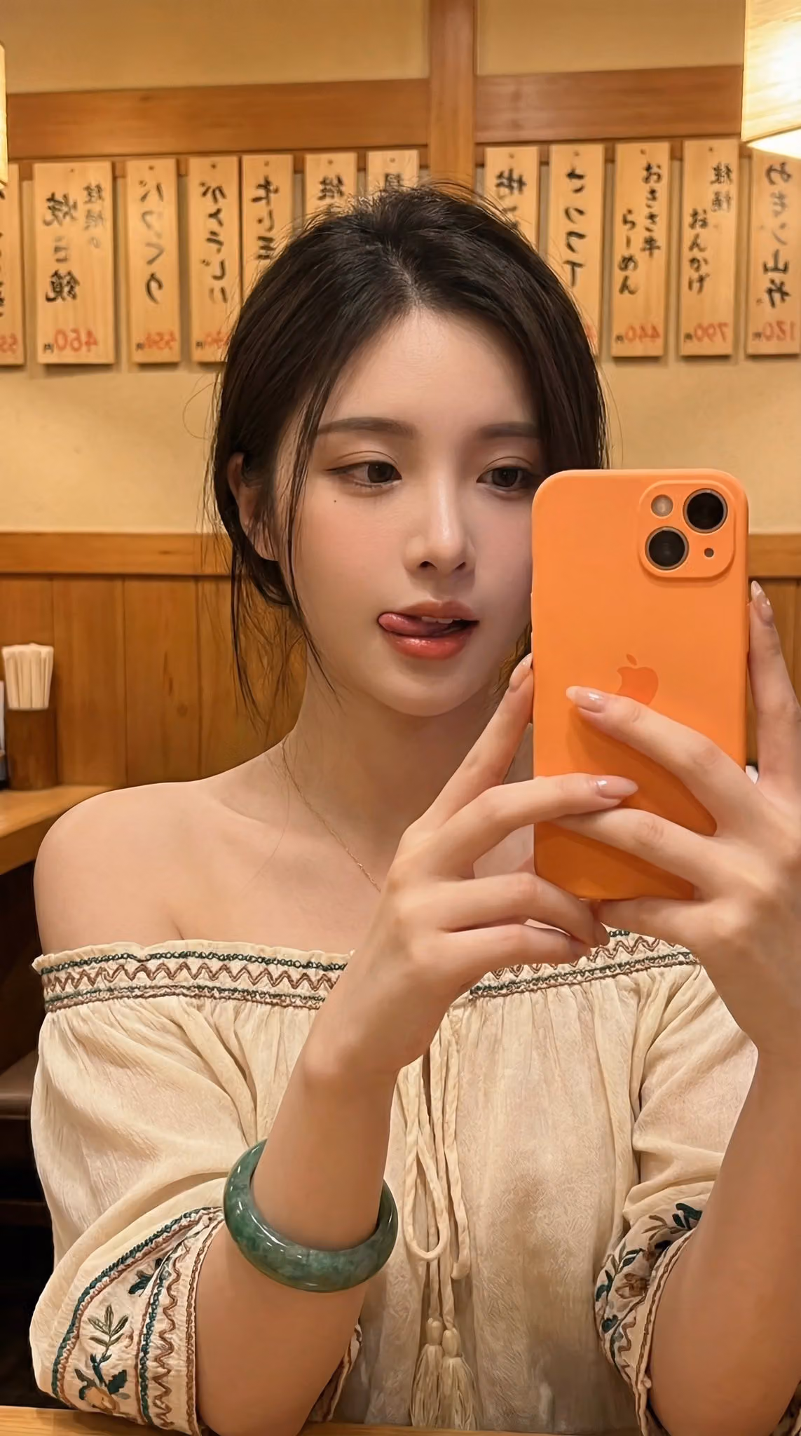 Close-up Selfie of Young Woman Holding Orange Phone